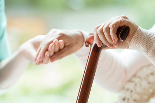 Elder person supported on cane